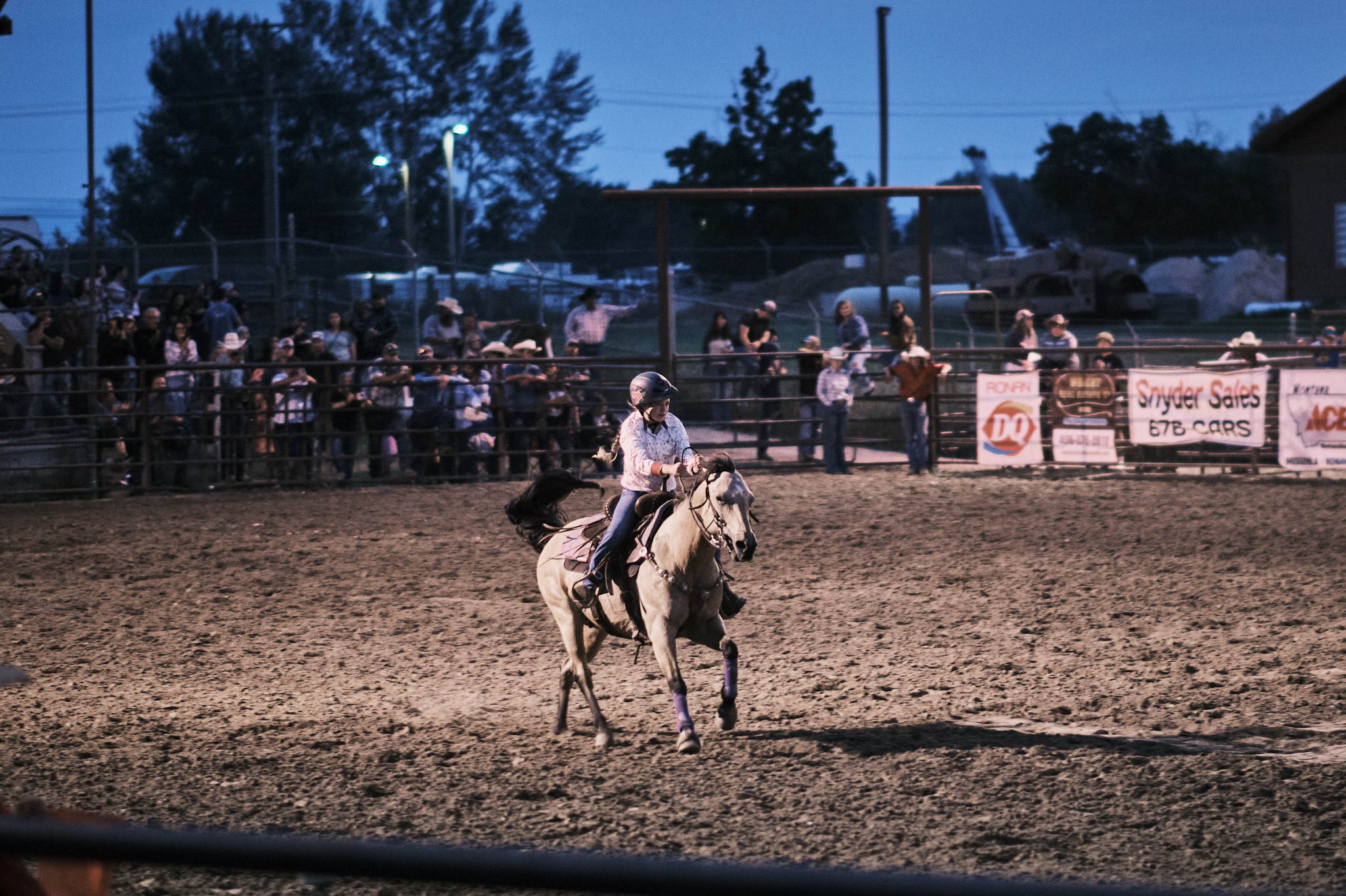 A cowgirl on her horse sprinting to the finish line during a barrel race