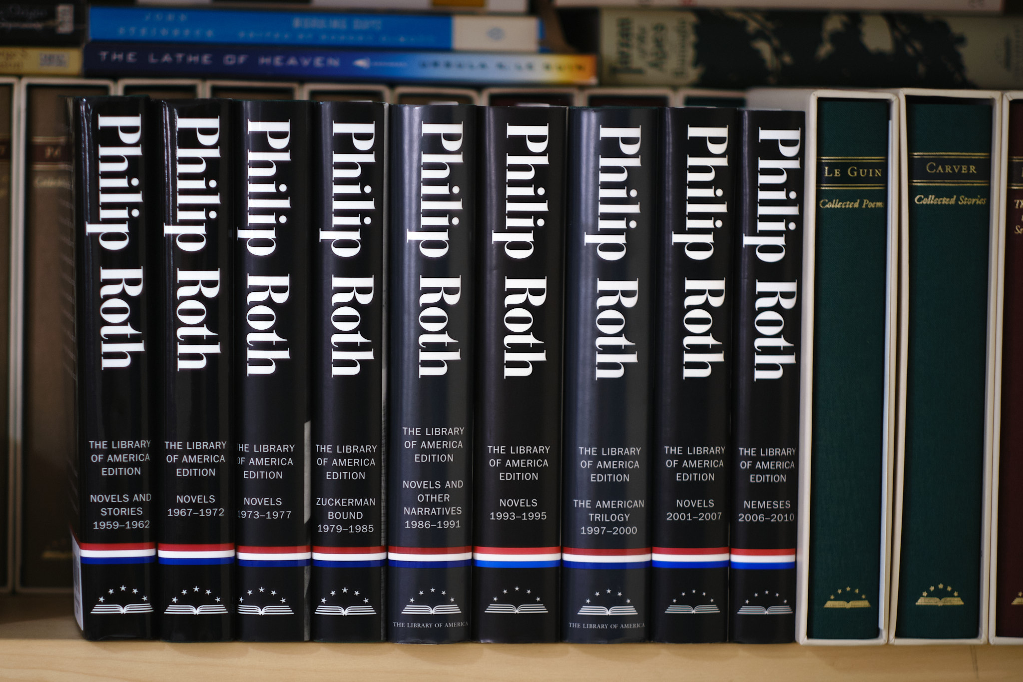 Library of America's nine volume collection of Philip Roth's novels displayed on a bookshelf in chronological order