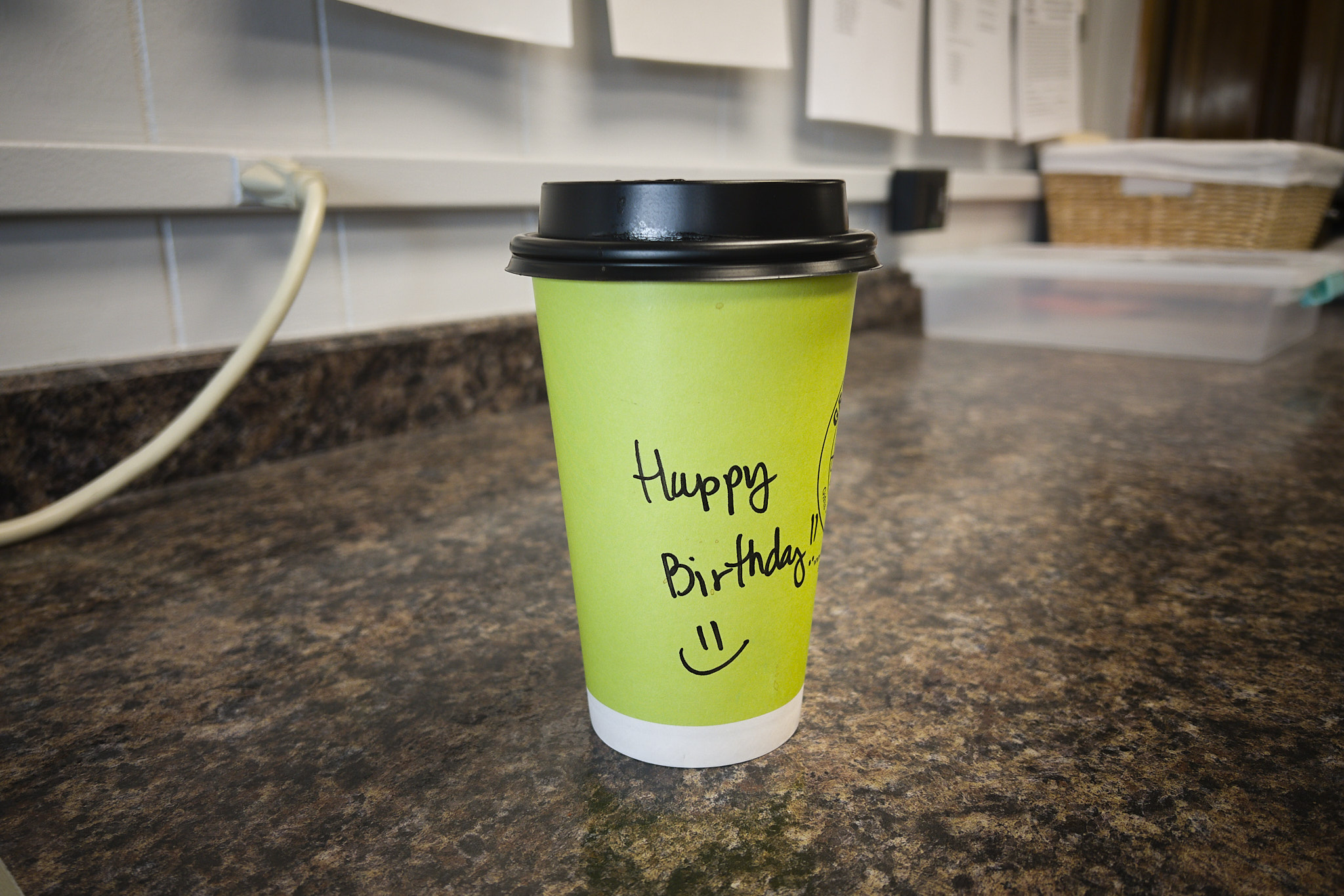 Coffee cup with Happy Birthday and a smiley face handwritten on it
